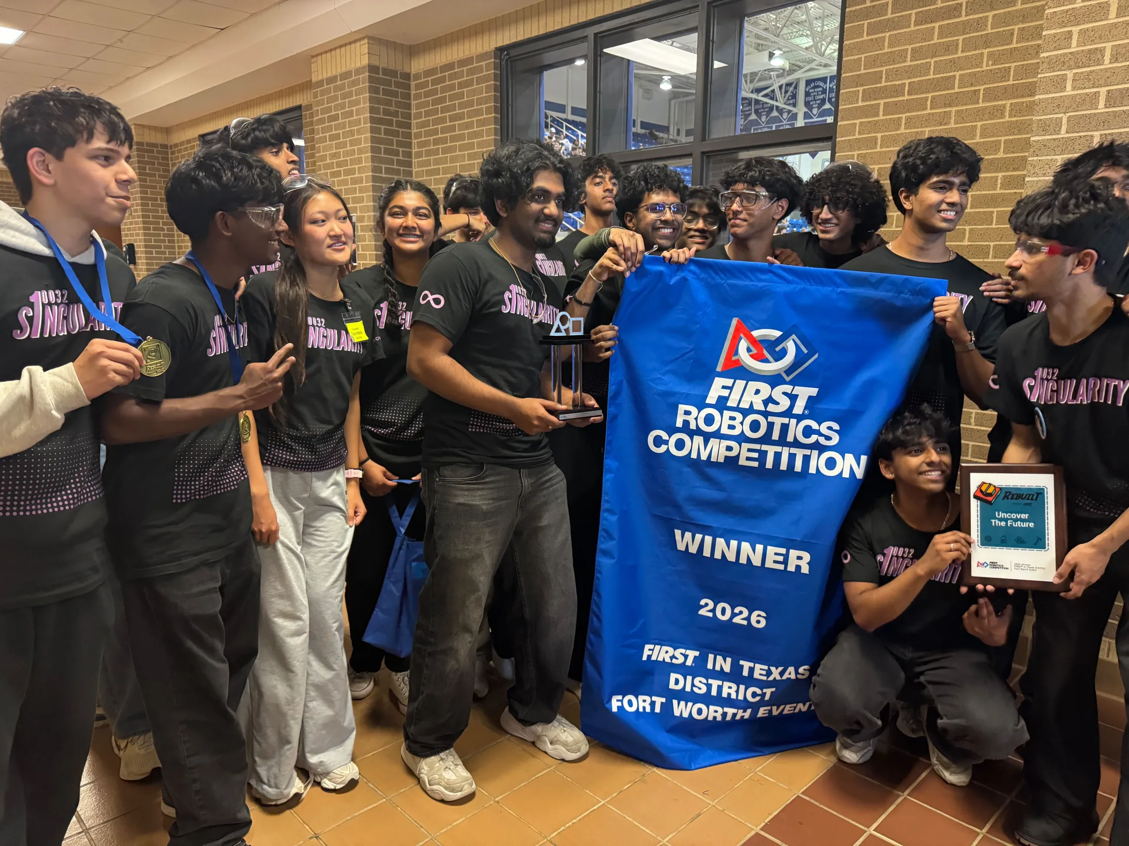 The team holds the winner banner at Fort Worth
