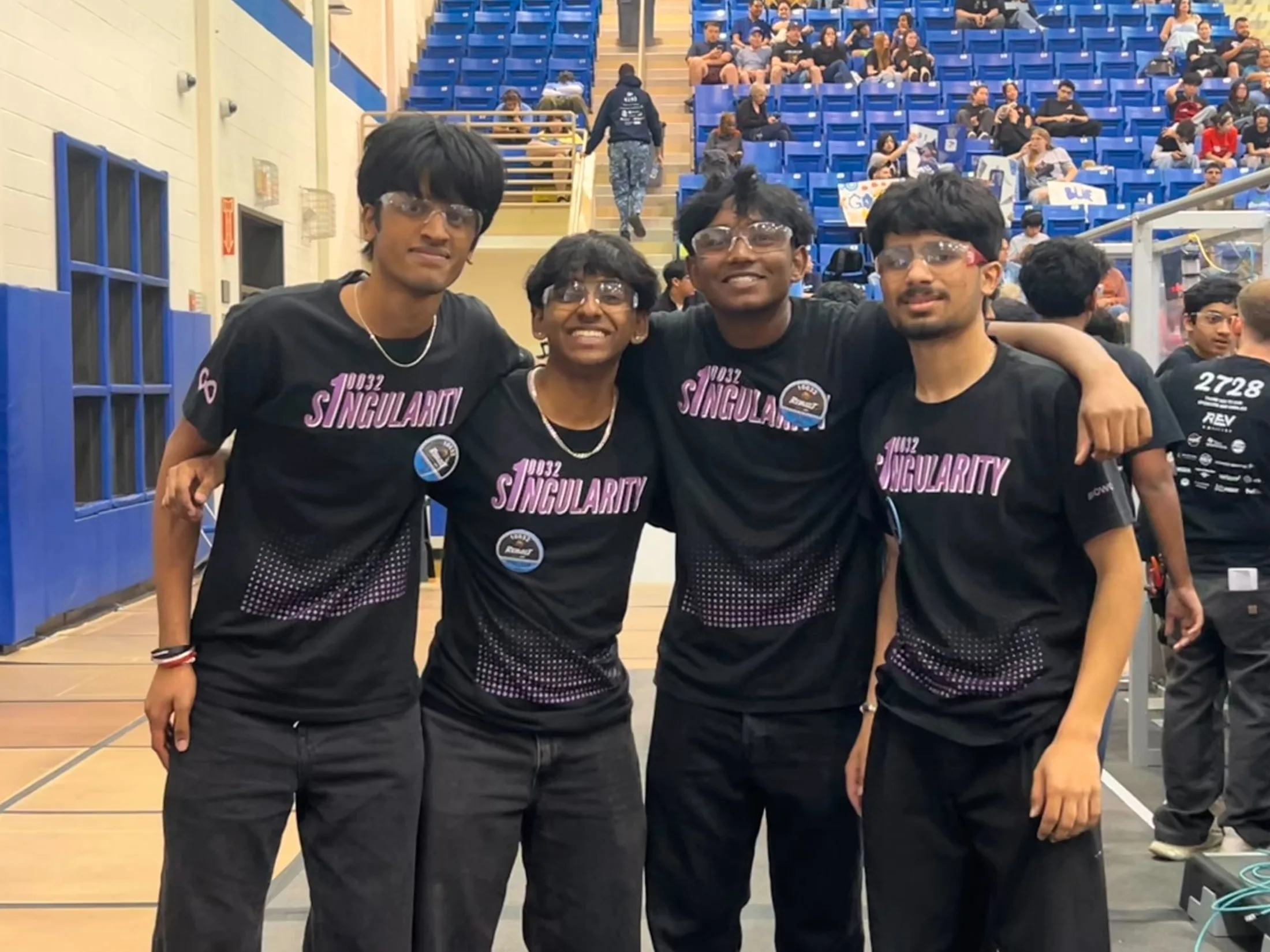 Four members in team jerseys at the arena