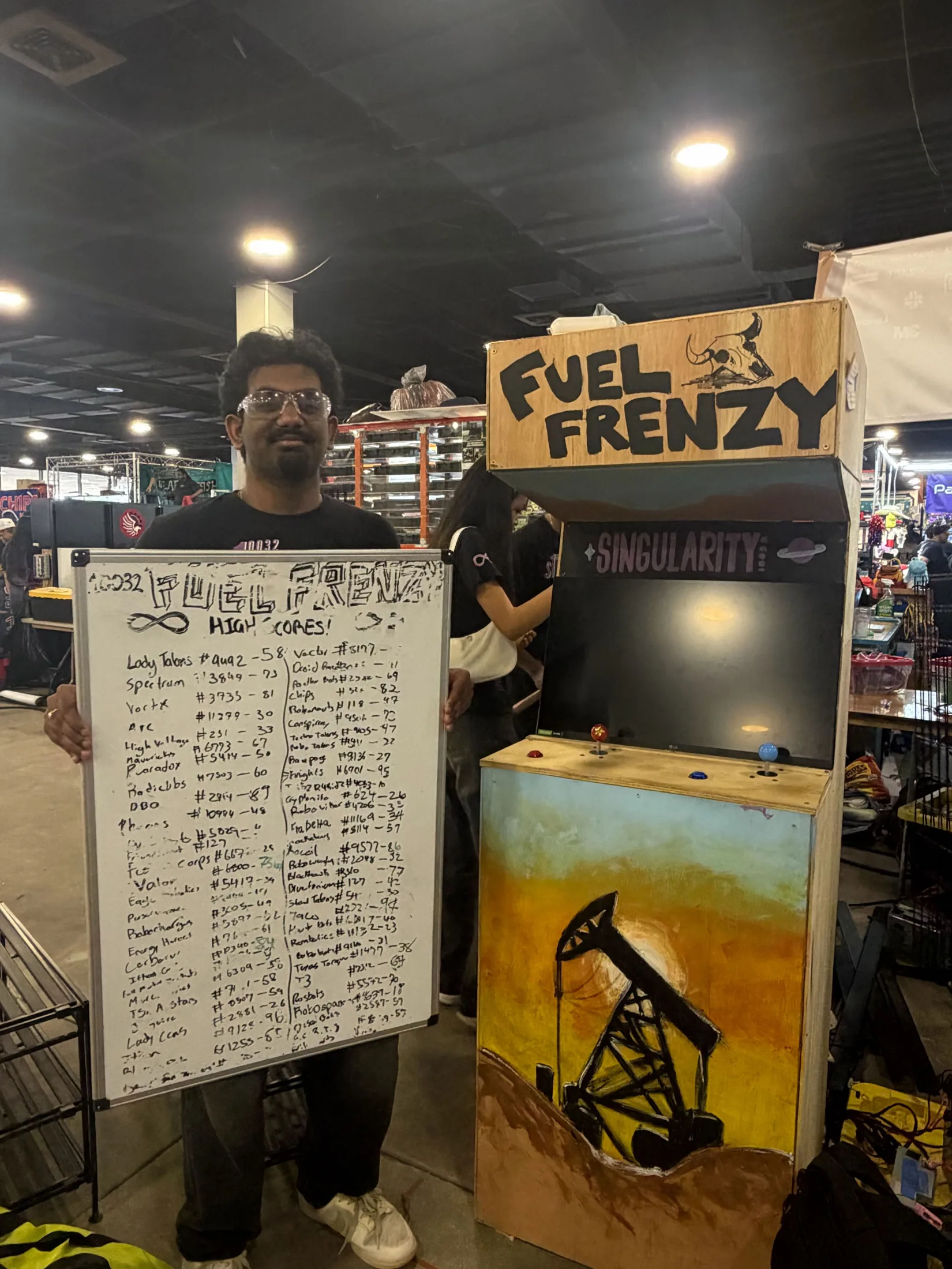 A student holding the arcade leaderboard whiteboard