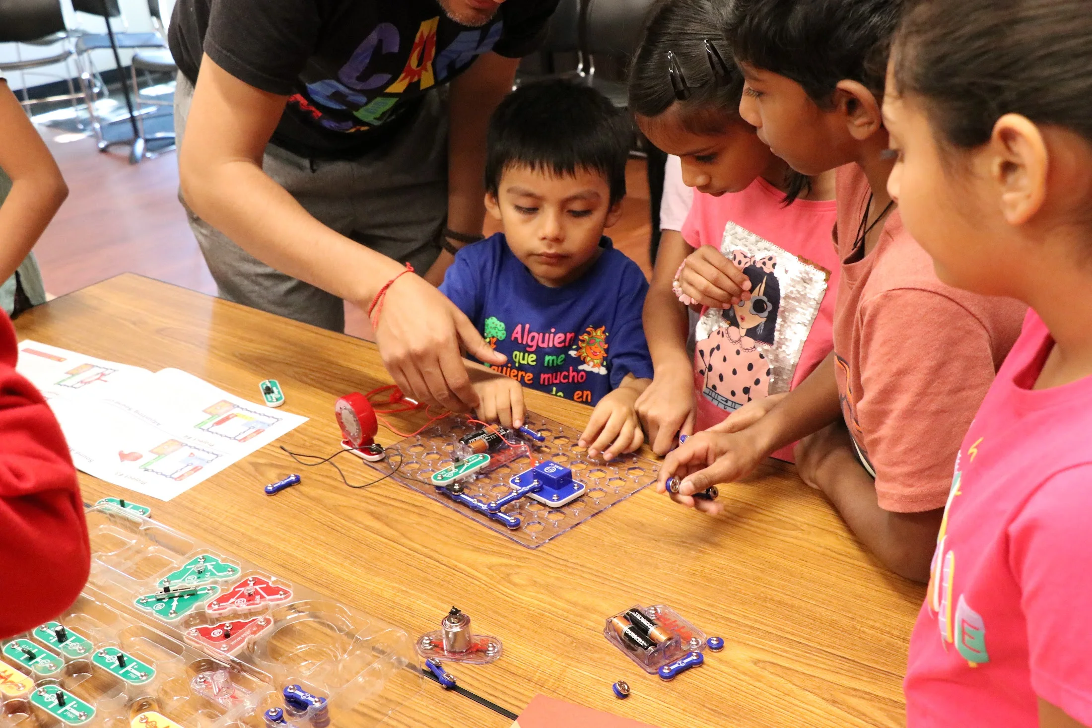 Volunteers helping kids build a snap circuit
