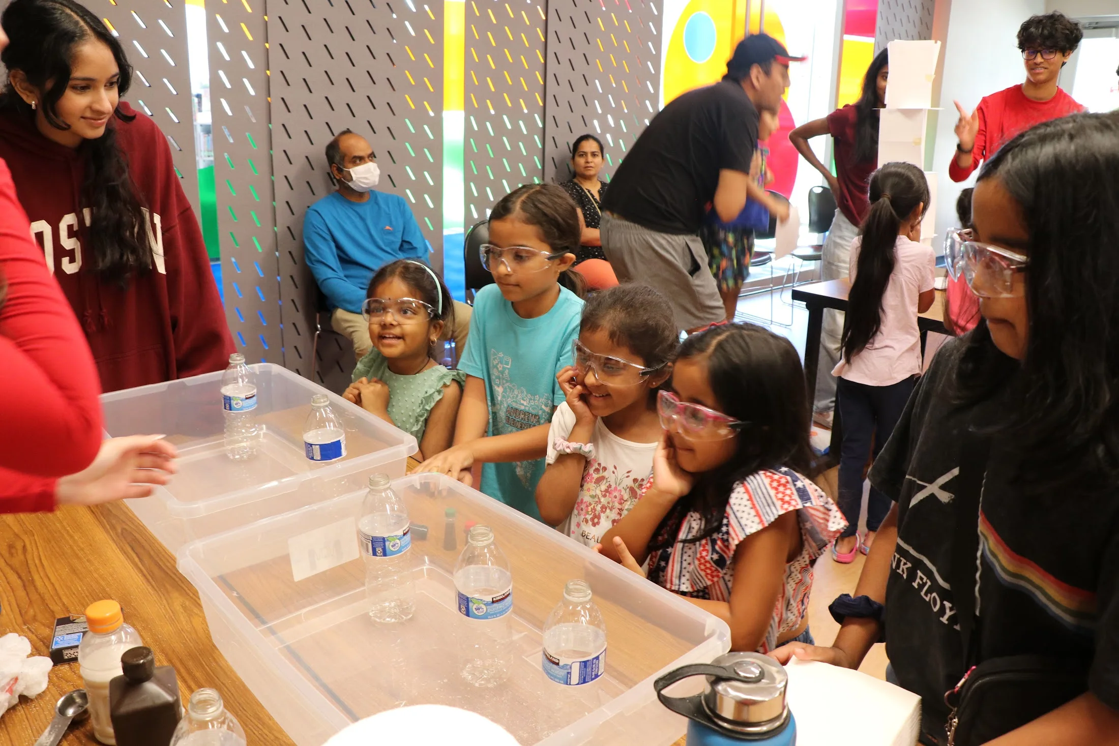 Kids gathered around the water-bin experiment