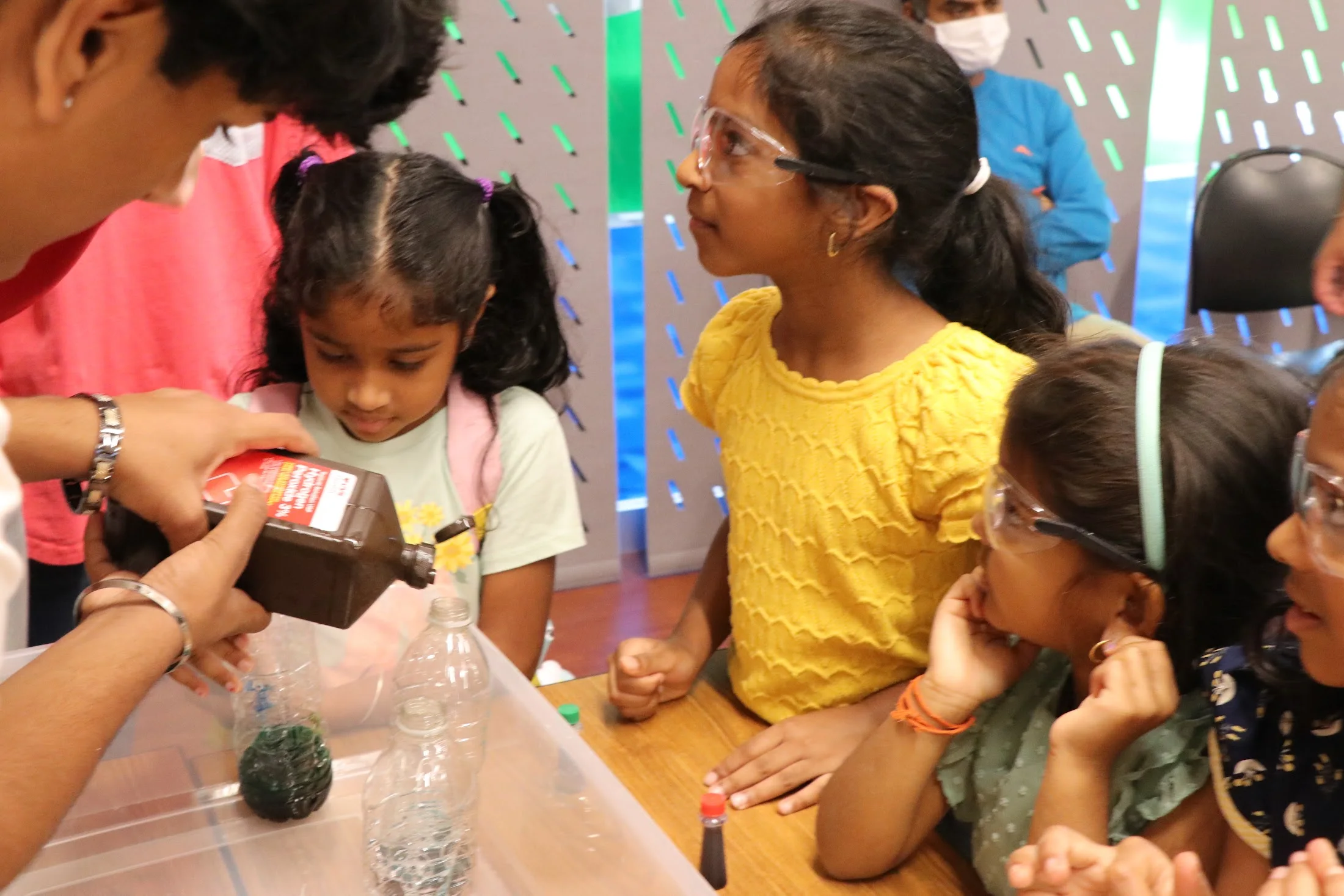 A volunteer guiding kids through the bottle experiment