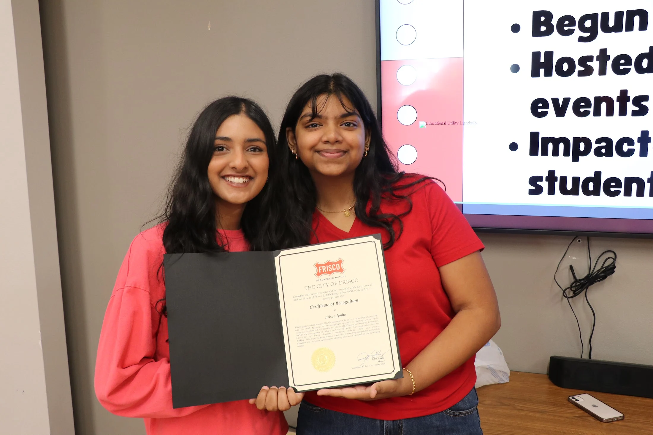 Two Frisco Ignite leads holding the City of Frisco Certificate of Recognition signed by Mayor Jeff Cheney