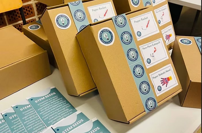 STEM Seeds activity kits boxed up: Paper Rocket, Pom-Pom Catapult and Paper Robotic Hand, with info cards